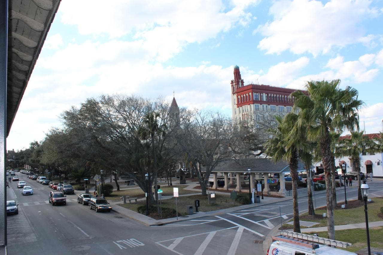 The Plaza de la Constitucion in downtown St. Augustine, with the Cathedral Basilica spire and the Casa Monica tower rising above the palms.